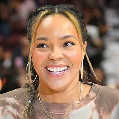 a close up of a person with a smile on her face and hair in pigtails