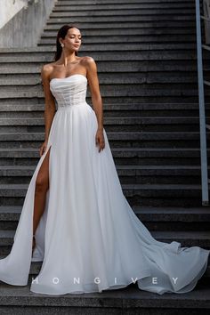 a woman in a white dress standing on some steps