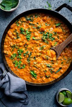 a skillet filled with red lentula and spinach, garnished with cilantro