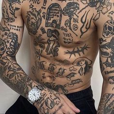 a man with many tattoos on his chest and arms is standing in front of a white wall