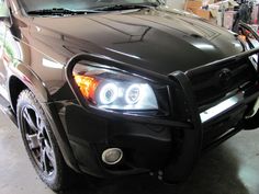 the front end of a black suv in a garage