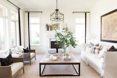 a living room with couches, chairs and a coffee table in front of a fireplace