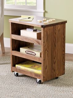 a small wooden table with books on it in front of a window and carpeted floor