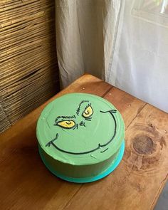 a green cake sitting on top of a wooden table