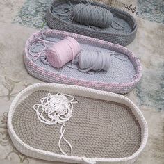 three crocheted baskets with yarn in them on the floor next to each other