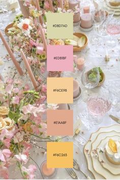 the table is set with pink and yellow flowers, candles, plates and napkins