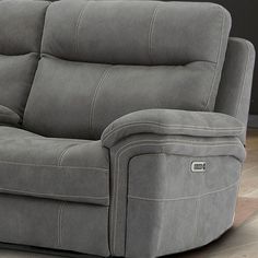 a grey reclining couch with two pillows on it's back and armrests