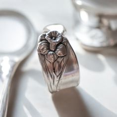 a close up of a spoon and some silverware on a white table with other items