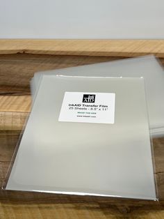 clear plastic sheets are stacked on top of each other in front of some wood planks