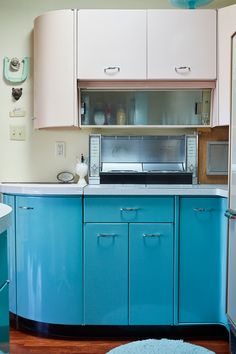 a kitchen with blue cabinets and white appliances