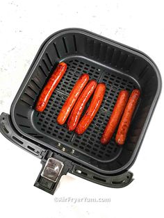 four hot dogs are being cooked on a grill