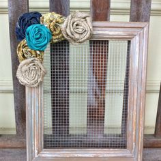 an old window frame decorated with fabric flowers