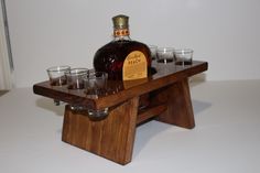 a wooden tray with glasses and a bottle on it sitting on top of a table