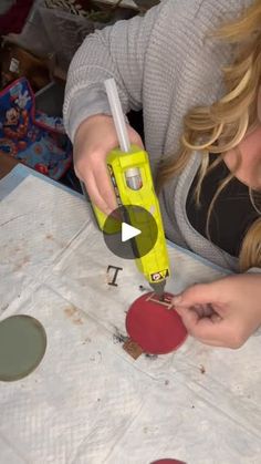 a woman is working on some crafts with scissors