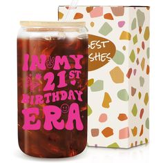 a glass jar filled with iced tea next to a cardboard box that says happy 21st birthday era