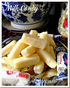 a plate full of cheese sticks next to a blue and white bowl with candy in it