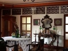 a dining room table and chairs in front of an ornate wall with wooden paneling