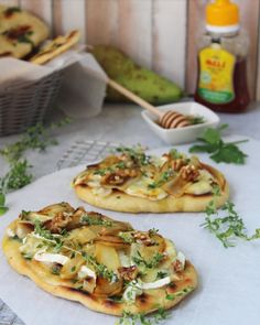 two flat bread pizzas sitting on top of a table