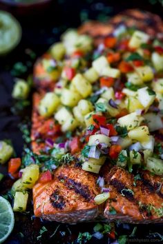 grilled salmon with pineapple salsa and lime wedges