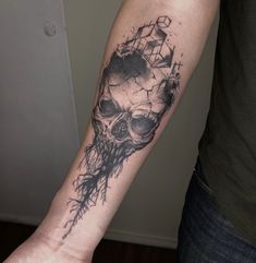 a man's arm with a skull and cubes tattoo on it