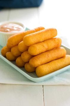 there are some fried food on the plate and dipping sauce in the bowl next to it