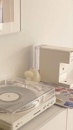 a record player sitting on top of a table next to a cd player and other items