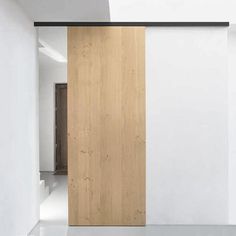 an empty room with a wooden door and white walls