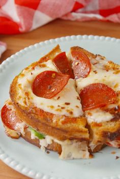 two slices of pizza on a plate with cheese and pepperoni cut into four pieces