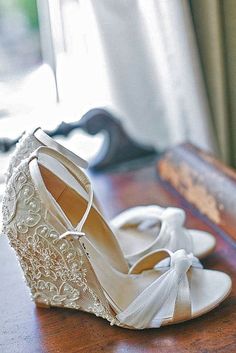 a pair of white shoes sitting on top of a wooden table