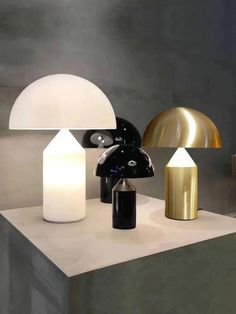 three different types of lamps sitting on top of a white table next to each other