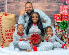 a family posing for a christmas photo in front of presents