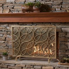 a fire place with a stone fireplace in the middle and a potted plant on top