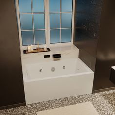 a white bath tub sitting in a bathroom next to a window with candles on it