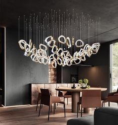 a modern chandelier hanging from the ceiling in a dining room with dark walls