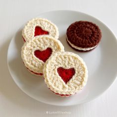 three crocheted cookies on a white plate