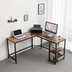 a corner desk with a laptop and monitor on it in an office setting, next to a potted plant