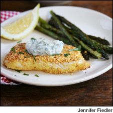 a white plate topped with fish and asparagus