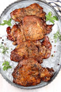 grilled pork chops on a plate with herbs