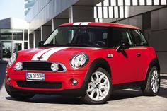 a red and white mini car parked in front of a building