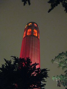 a tall tower with a clock on it's side lit up in the night