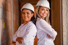 two women wearing hard hats standing next to each other