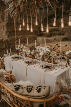 a table set up with candles, plates and place settings