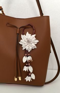 a brown handbag with white flowers on it