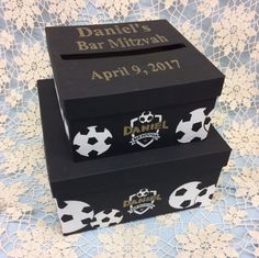 two black boxes with white soccer balls on them