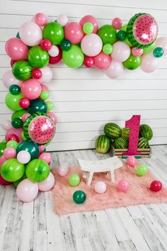 the balloon arch is decorated with watermelon and pink, green, and white balloons