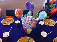 the table is set with candy, plates and napkins on it for an event