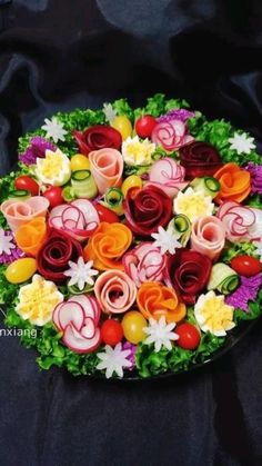 a platter filled with lots of different types of flowers on top of black cloth