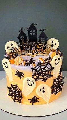 a halloween cake with white frosting and black decorations