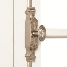 an ornate door handle on a white wooden door