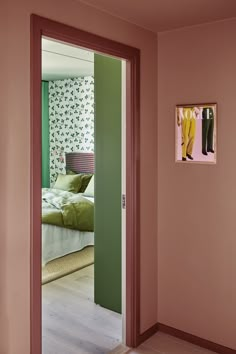 an open door leading to a bedroom with pink walls and green carpeted flooring